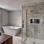 Salle de bain moderne avec douche et baignoire.