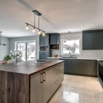Cuisine moderne avec îlot central et luminaires suspendus.
